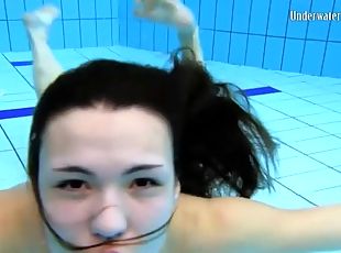 Beautiful girl swims and smiles underwater